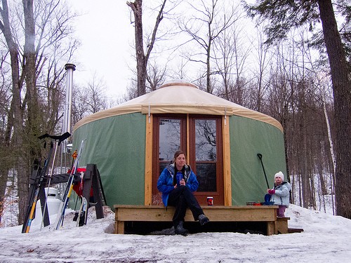 lady sitting outside camping tent during winter