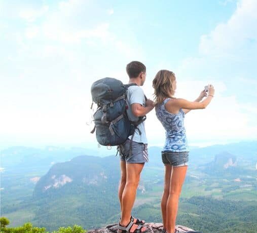 man and woman on top of the hill taking picture