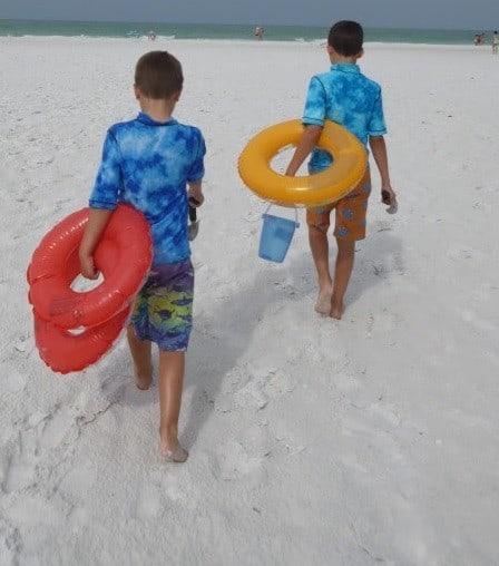 2 boys walkingon white sand