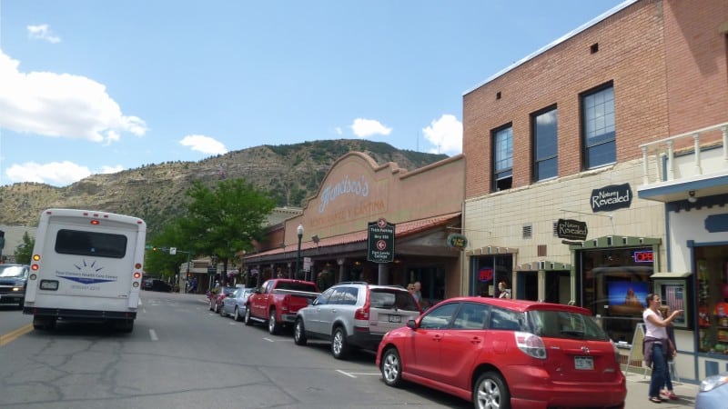 downtown street with stores and cars